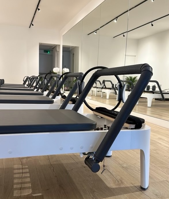 Bright reformer pilates studio with neatly lined reformers